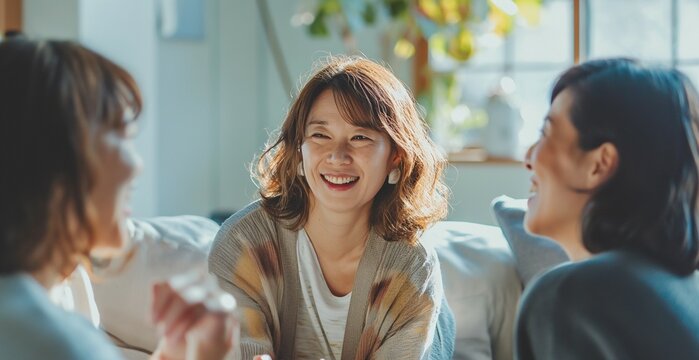明るいリビングで楽しく会話する日本の中年女性三人組