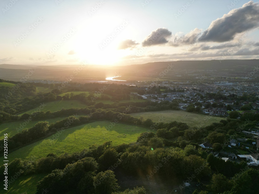 Poster Aerial view of a countryside landscape dotted with trees at sunset