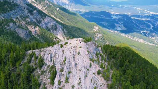 Aerial video of the rocky mountains covered with fir trees on a sunny day
