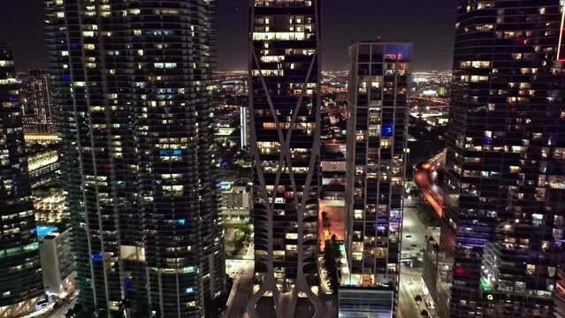 Drone footage of high colorful Miami downtown Financial district and street traffic at night