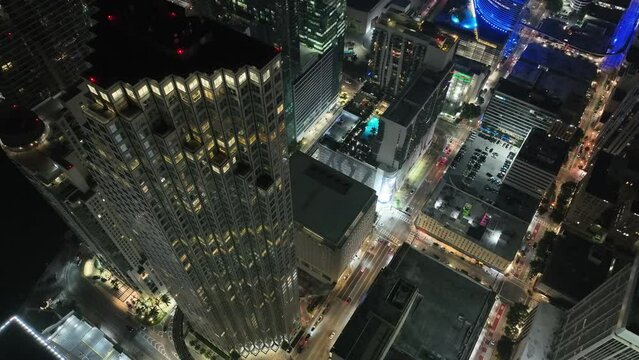 Drone descending over high Miami downtown Financial district and street traffic at night