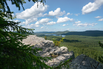 Fototapeta na wymiar Ryläys Hill lookout point scree stones, and lake in Koli National Park, North Karelia, Finland. Hiking trail with lake view and forest, finnish nature in the summer in the Herajärven kierros Trail.