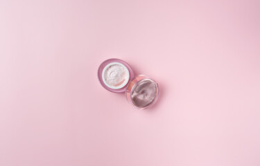 Jar of cream isolated on pink background, top view