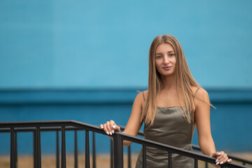 Portrait of a young beautiful blonde girl in a city summer park.