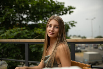 Portrait of a young beautiful blonde girl in a city summer park.