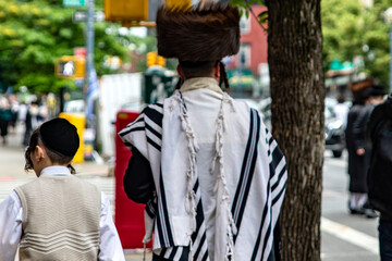 Two orthodox Jewish men in the Williamsburg neighborhood of Brooklyn, where there is a large community of this culture and one of the most striking contrasts in New York (USA). - obrazy, fototapety, plakaty