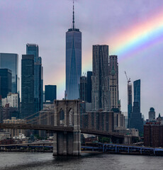 The Brooklyn Bridge with the rainbow linking the boroughs of Manhattan and Brooklyn in New York...