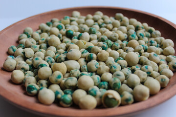Fried green peas with dough flour, on wooden plate