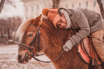 little rider looks fun hugging the neck of a pony 