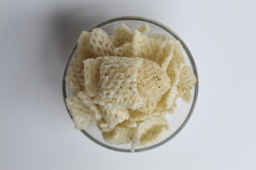 Crackers in net shape, in transparent glass bowl. isolated on white background, flat lay or top view
