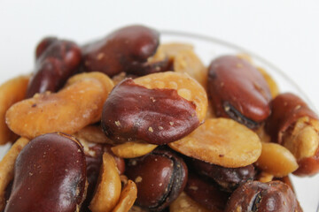 Kacang koro, or cooked jack bean, in a transparent glass bowl, isolated on white background