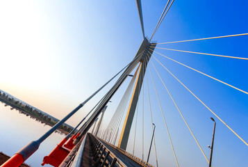 Cable-stayed bridge in the light of the morning sun and against the background of a clear blue sky....