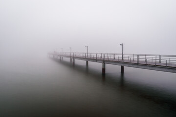 Pier in Tagus river with fog - Lisbon, Portugal