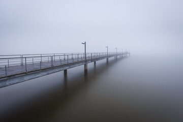 Pier in Tagus river with fog - Lisbon, Portugal