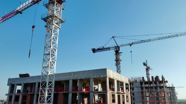 Cranes effortlessly tackle construction of buildings. Industrial development of city propelled forward with invaluable assistance of tower cranes