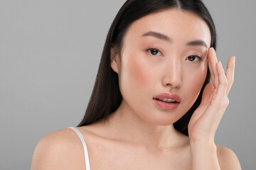 Beautiful woman with healthy skin on gray background, space for text