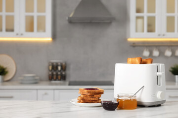 Making toasts for breakfast. Appliance, crunchy bread, honey and jam on white table in kitchen. Space for text