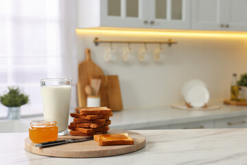 Breakfast served in kitchen. Crunchy toasts, honey and milk on white marble table. Space for text