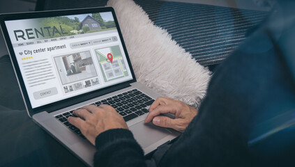 Fototapeta premium Man reading rental home ads online. Booking vacation in house for rent. Travel, business, concept.