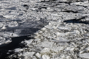 ice drift on the river. Floating of ice floes in dark water © Konstantin