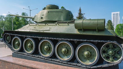Fototapeta na wymiar Suspension and tracks of the tank. Soviet medium tank of the Second World War. Military armored vehicles. Tank on a pedestal.