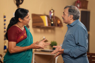 Obraz premium Indian senior married couples arguing each other while talking or during communication at home - concept of Conflict, family problems and misunderstanding