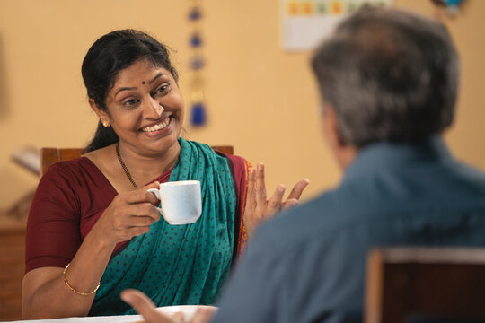 shoulder shot of Indian senior couple enjoying morning tea or coffee at home - concept of companionship, spending family time, refreshment - Powered by Adobe