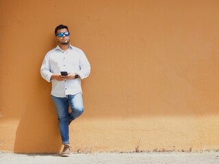 man leaning against an orange wall