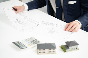物件の構造を検討するビジネスマンの手元