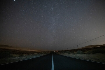 Carretera al infinito, cielo nocturno con vía láctea, cielo lleno de estrellas - obrazy, fototapety, plakaty