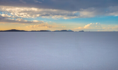 Sunset over the endless expanses of solid flat Salar de Uyuni, the world's largest salt flat,...