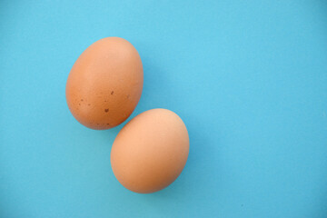 Uncooked egg on pastel blue background. Minimal food concept with copy space