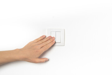 Closeup of hand and light switch. Womans hand with fingers on light switch, about to turn off the...