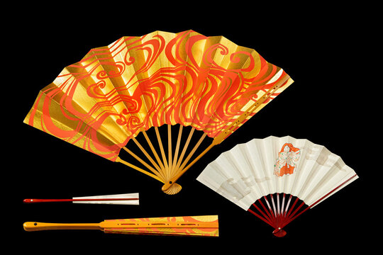 Japanese traditional hand fans from paper and bamboo with gold and red ornament, isolated on black
