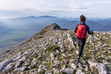 Obraz premium Hiker walking along a rocky ridge. Sierra de Andia, Navarra