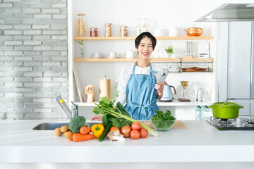 キッチンに立つ笑顔の若い女性