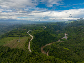 Mountain with rainforest and river in Mindanao. Blue sky and clouds. Philippines.