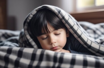 Peaceful face of a baby who is sleeping, cute baby sleeping under a checkered blanket