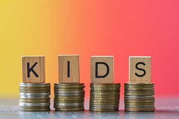 Wooden blocks spell "Kids" on coins