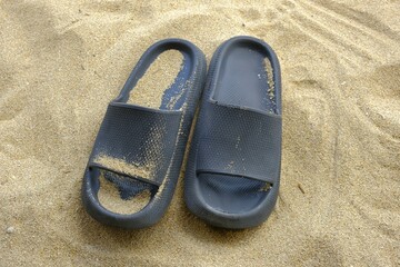 A pair of sandals on sands at beach. Plastic sandals for man