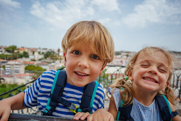Happy portrait of two kids travelers at Lisbon viewpoint