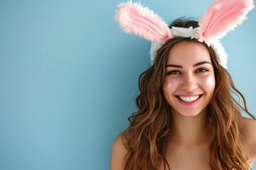 Happy young woman wearing easter rabbit headband with ears on background.