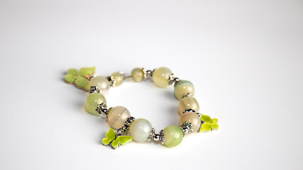 Beads from light green and yellow stones on a white background