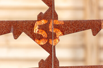 The number 55 on a rusty metal fence