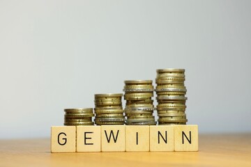 Geld Gewinn, Preisgeld eines Wettbewerbs oder Gewinn eines Unternehmens symbolisiert durch Geldstapel, Geldmünzen und einen Schriftzug