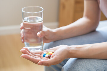Sick, asian young woman, girl hand holding pill capsule, painkiller medicine from stomach pain,...