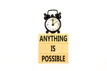 Anything is possible symbol. Concept words Anything is possible on beautiful wooden blocks. Beautiful white table white background. Black alarm clock. Business anything possible concept. Copy space.