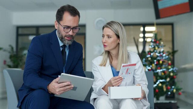 Pharmaceutical sales representative talking with doctor in medical building. Female doctor talking with hospital director, manager in private clinic.