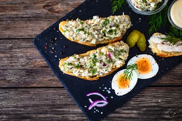 Foto op Canvas Tasty sandwich with egg salad and smoked mackerel on wooden table  © Jacek Chabraszewski