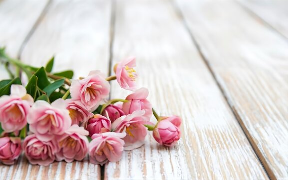 Pink flowers on white wooden background. Selective focus